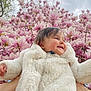 baby, blossoms, child, cloudy_sky, cute, face, flowering_tree, fluffy_coat, hands, happy, magnolia, nature, outdoor, person, pink_flowers, portrait, seasonal, smiling, spring, warm_clothing