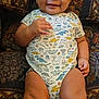 Prince Daniel is registered to the contest to win money with this photo: baby, infant, smiling, onesie, dinosaur_print, couch, patterned_fabric, happy, child, indoor, person, cute, young_child, furniture, relaxed, skin, portrait, sitting, hand, legs