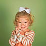 child, girl, blonde_hair, curly_hair, bow, smile, striped_clothing, floral_pattern, long_sleeves, portrait, green_background, cute, happy, innocent, young, posing, studio_photo, fashion, person, toddler
