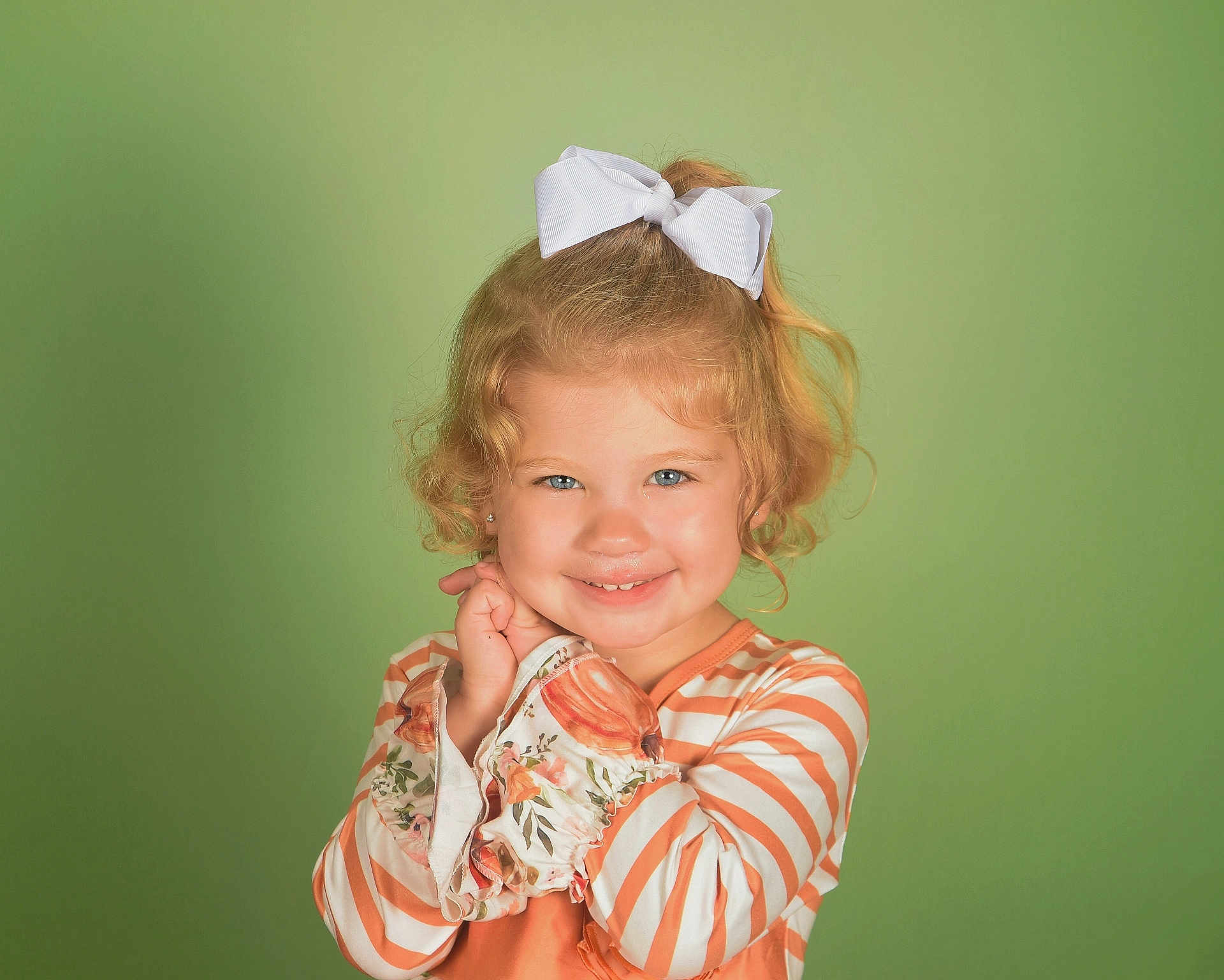 Mia joined the competition — help win amazing prizes! child, girl, blonde_hair, curly_hair, bow, smile, striped_clothing, floral_pattern, long_sleeves, portrait, green_background, cute, happy, innocent, young, posing, studio_photo, fashion, person, toddler