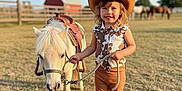 Génesis Martinez joined the competition — help win amazing prizes! animal, barn, brown_pants, child, cowgirl, cute, farm, fence, grass, hat, horse, outdoor, pet, pony, ranch, rope, sleeveless_shirt, smiling, standing, sunny