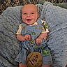 Waylon is registered to the contest to win money with this photo: baby, infant, smiling, overalls, clothing, dinosaur_print, blanket, blue_blanket, wooden_sign, two_months, happy, cute, portrait, lying_down, head, face, skin, hands, feet, indoor