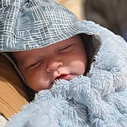 Waylon is registered to the contest to win money with this photo: baby, sleeping, hood, blanket, soft_texture, close_up, face, peaceful, child, infant, cozy, wrapped, patterned_clothing, resting, cute, warm, portrait, indoor, young_child, toddler