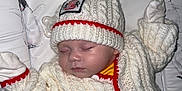 Jaxson joined the competition — help win amazing prizes! animal, baby, beanie, bed, bird, bonnet, cap, clothing, couch, face, furniture, glove, hat, head, knitwear, penguin, person, photography, portrait, sweater