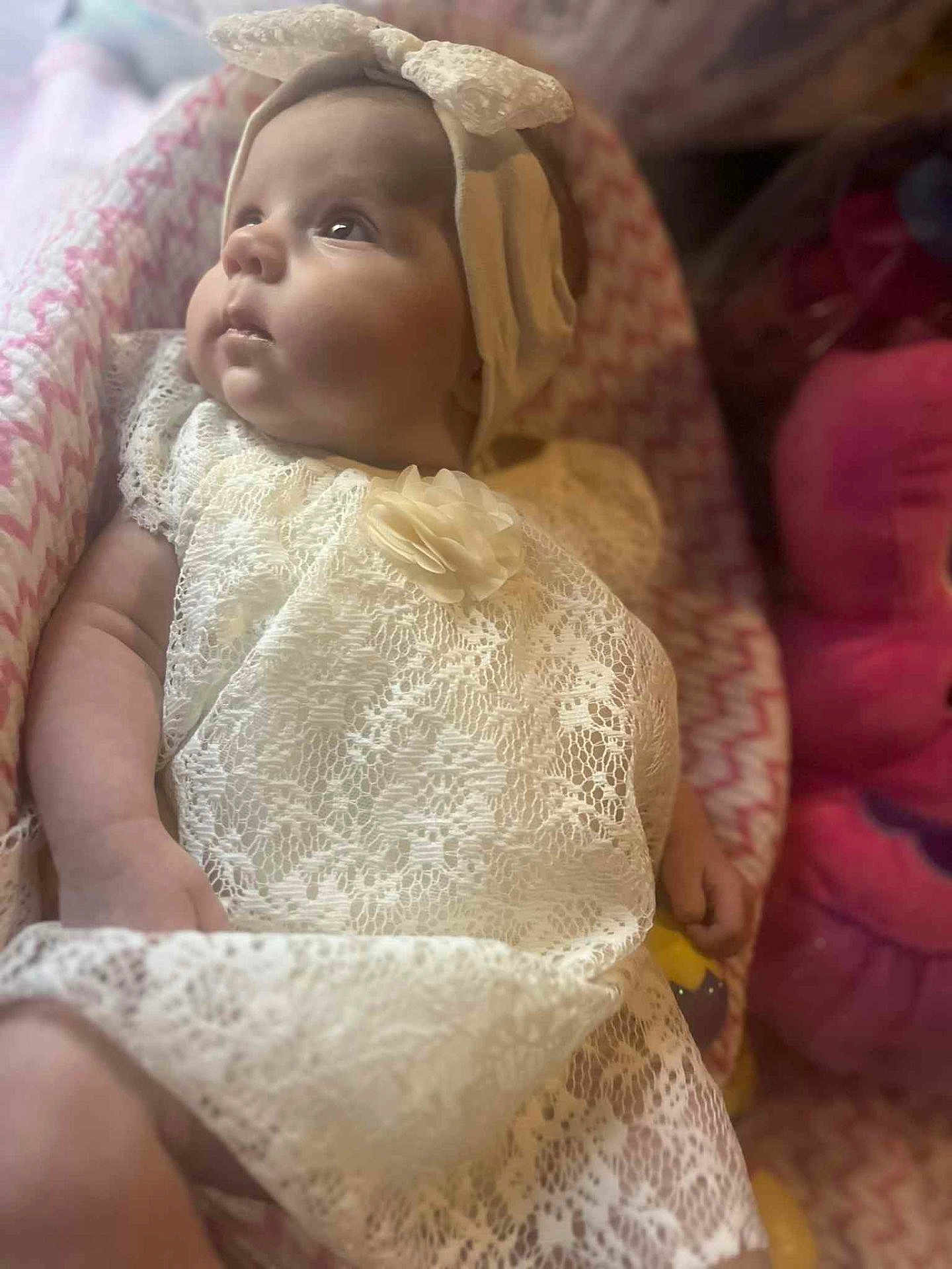 Alora is registered to the contest to win money with this photo: baby, infant, lace_dress, headband, bow, blanket, pink, cute, portrait, child, newborn, soft_lighting, indoor, cozy, adorable, gaze, clothing, closeup, young, person
