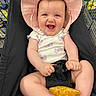baby, infant, smiling, hat, pink_hat, shopping_cart, plush_toy, onesie, butterfly_pattern, child, happy, cute, retail, store_shelves, household_products, shopping, seat, person, indoor, toy