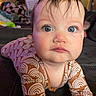 Lyla joined the competition — help win amazing prizes! baby, child, infant, face, blue_eyes, brown_hair, patterned_clothing, rainbow_pattern, long_sleeves, indoor, living_room, couch, soft_lighting, curious_expression, portrait, closeup, person, skin, head, toddler