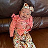 Octavia joined the competition — help win amazing prizes! baby, child, smiling, winking, headband, floral, pink_clothing, patterned_pants, socks, couch, leather, indoor, happy, cute, portrait, sitting, young_child, infant, apparel, fashion