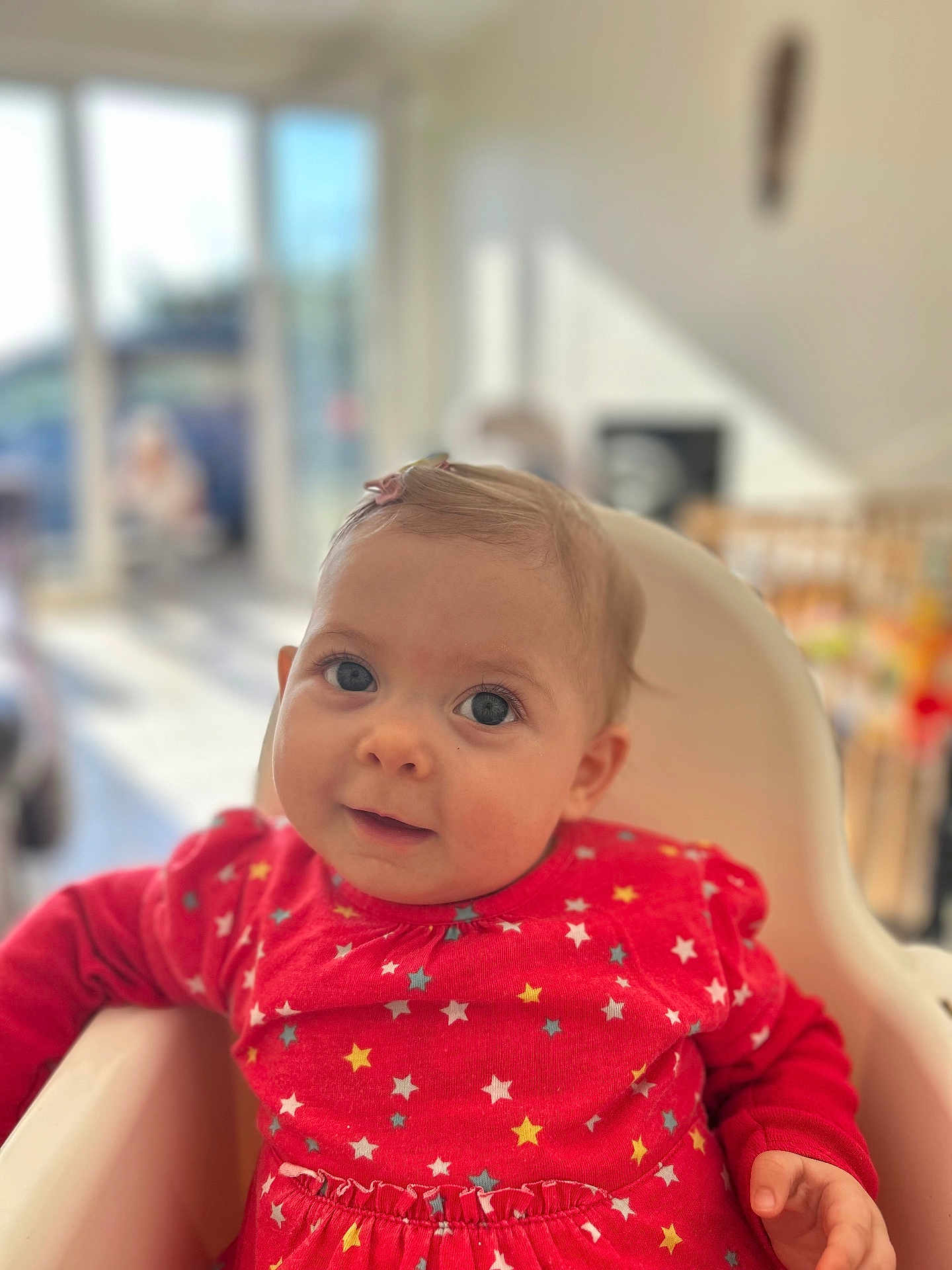 Sinaï a rejoint le concours — aidez-le/la à gagner de superbes lots ! baby, child, high_chair, red_clothing, star_pattern, indoor, daylight, face, smile, curious, blond_hair, blue_eyes, person, infant, furniture, home, soft_focus, portrait, cute, seated