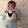 baby, bedspread, blue_clothing, child, cute, eyes, face, hand, head, indoors, infant, lying_down, pajamas, patterned, person, plush_toy, sheep, sleepwear, sleepy, soft_toy