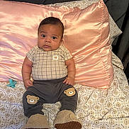 Alexander is registered to the contest to win money with this photo: baby, bear_patch, bed, blanket, child, clothing, curious, cute, droplet, expression, face, footwear, home, indoor, infant, pattern, person, pillow, sitting, soft_toys