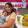 baby, casual_clothing, drink_cup, food, glasses, happy, holding, indoor, people, portrait, retail, seating_area, shopping_mall, smiling, store, table, target_sign, wetzels_pretzels, woman, yellow_bag