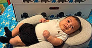 Alexander joined the competition — help win amazing prizes! baby, baby_bundle_box, bedspread, black_shorts, blue_bedspread, child, clothing, colorful, comfortable, cushion, cute, elephant_logo, face, home, indoor, infant, lying_down, patterned_bedspread, person, white_shirt