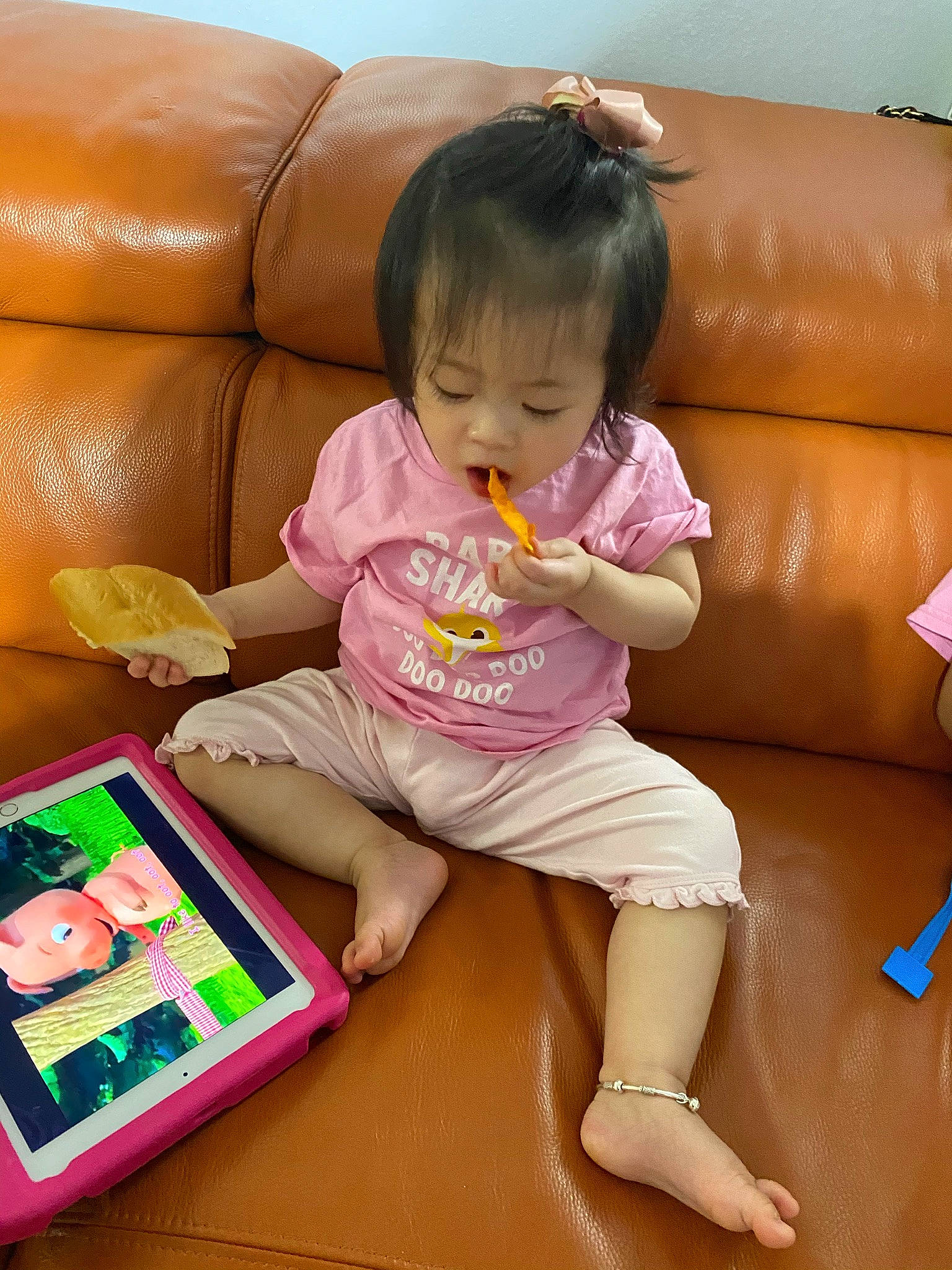 Jolie is registered to the contest to win money with this photo: baby_toddler_clothing, child, comfort, couch, finger, floor, flooring, foot, fun, hair, human_leg, lap, leisure, person, pink, play, room, sitting, snapshot, thigh