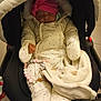 baby, infant, sleeping, stroller, blanket, pink_hat, winter_clothing, padded_suit, toy, beads, indoor, child, cute, cozy, warm, face, hand, footwear, person, toddler