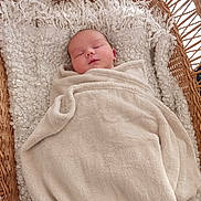 Jason a rejoint le concours — aidez-le/la à gagner de superbes lots ! baby, blanket, basket, sleeping, cozy, soft_texture, infant, swaddled, resting, cute, child, woven, fabric, cushion, peaceful, indoor, portrait, head, face, wrapped