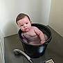 baby, bucket, water, bathroom, showerhead, floor, wall, child, naked, face, expression, plumbing, indoor, curious, black_bucket, wet, person, skin, head, tub