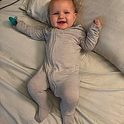 Greyson joined the competition — help win amazing prizes! arms_raised, baby, bed, bedroom, blanket, child, clothing, cuddly, happy, home, indoor, infant, lying_down, pacifier, photography, pillow, portrait, smiling, striped_onesie, stuffed_animal