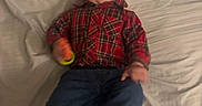 Greyson is registered to the contest to win money with this photo: baby, bed, bedding, bedroom, blue_pants, casual_clothing, child, colorful_toy, face, happy, indoors, infant, lying_down, photography, plaid_shirt, portrait, shoes, single_person, smiling, toy