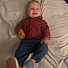 Greyson is registered to the contest to win money with this photo: baby, infant, child, smiling, portrait, lying_down, bed, bedding, plaid_shirt, blue_pants, shoes, toy, colorful_toy, indoors, bedroom, happy, face, single_person, casual_clothing, photography