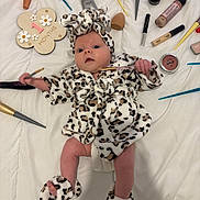 Lou a rejoint le concours — aidez-le/la à gagner de superbes lots ! baby, infant, leopard_print, robe, slippers, makeup_brush, foundation, cosmetics, white_sheet, sign, 1_month, face, hand, foot, lying_down, cute, newborn, headband, soft_texture, skin