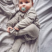 Tymeo a rejoint le concours — aidez-le/la à gagner de superbes lots ! baby, bed, child, comfort, cute, expression, face, foot, gray_clothing, hand, indoors, infant, lying_down, pacifier, pajamas, person, sheet, skin, sleepwear, wrinkles
