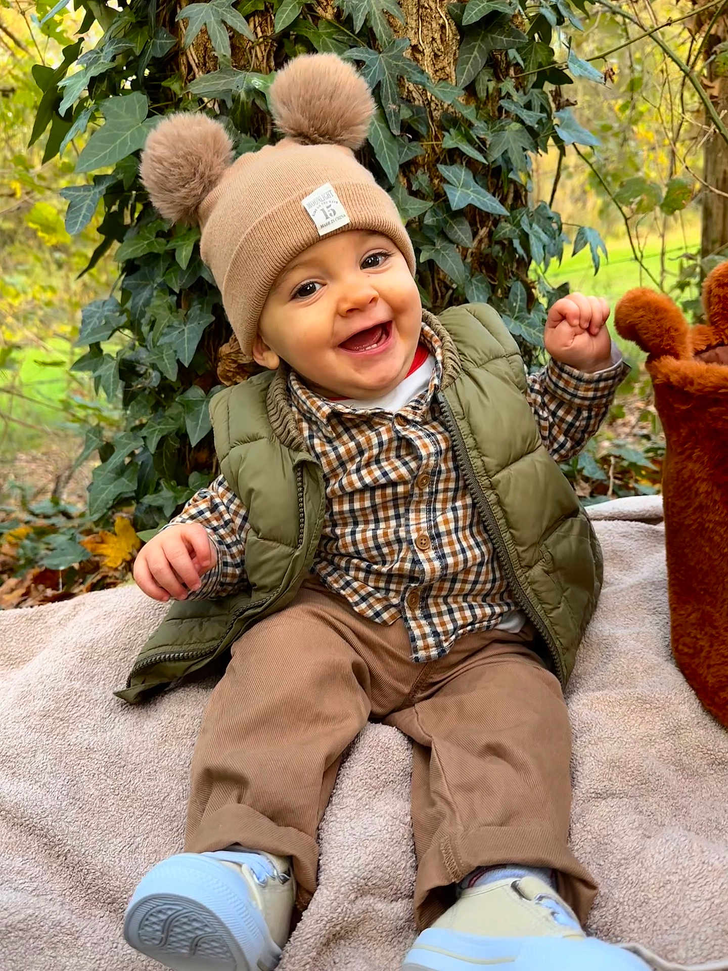 Sowen participe au concours pour gagner de l'argent avec cette photo : baby, child, smiling, hat, pom_pom, greenery, ivy, tree, outdoor, fall, plaid_shirt, vest, pants, sneakers, blanket, happy, nature, sitting, cute, portrait
