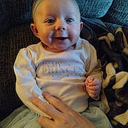 Bailey Lee joined the competition — help win amazing prizes! baby, blanket, bow, child, clothing, couch, cozy, cute, face, hand, happy, headband, indoor, infant, person, portrait, sitting, smiling, soft, tutu