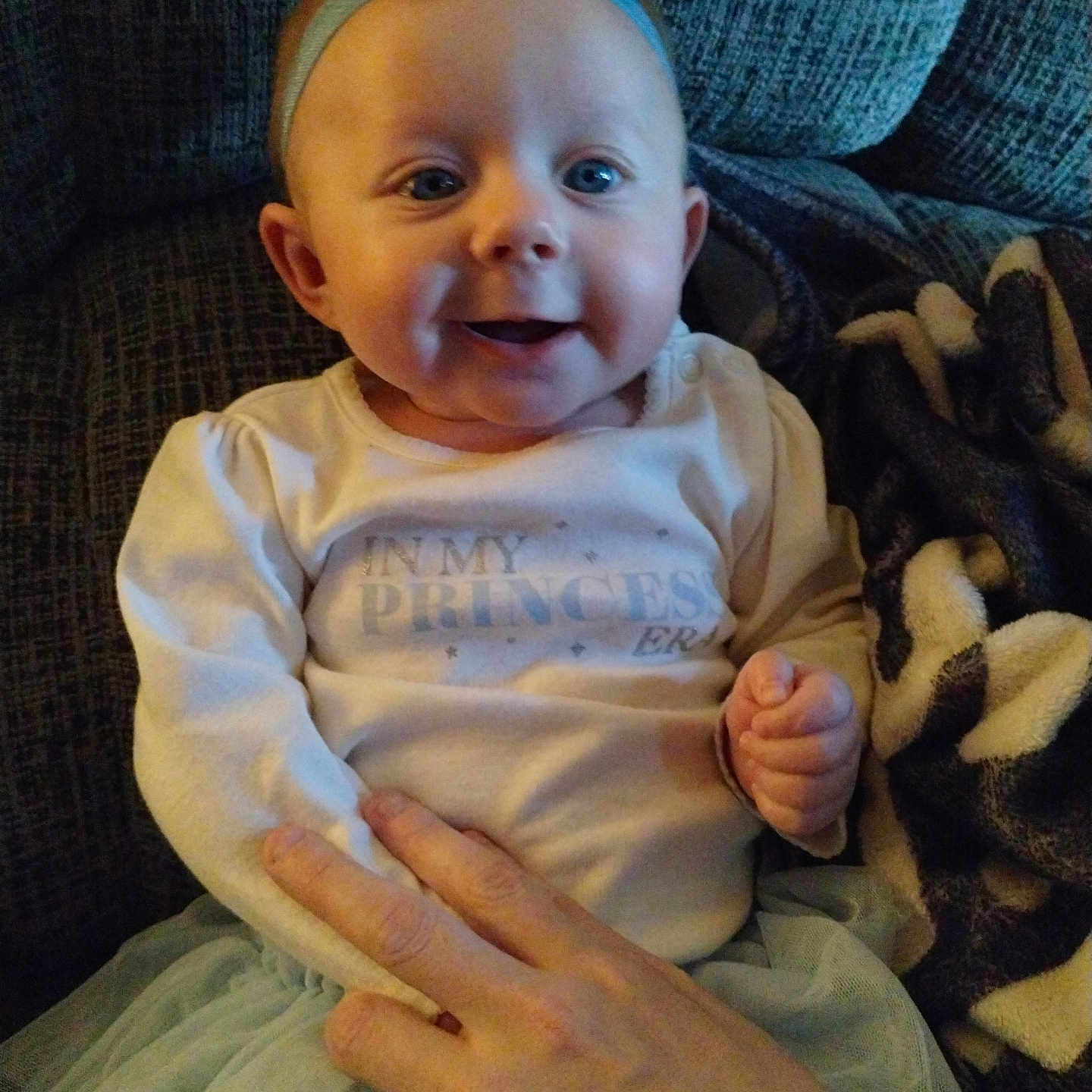 Bailey Lee joined the competition — help win amazing prizes! baby, blanket, bow, child, clothing, couch, cozy, cute, face, hand, happy, headband, indoor, infant, person, portrait, sitting, smiling, soft, tutu