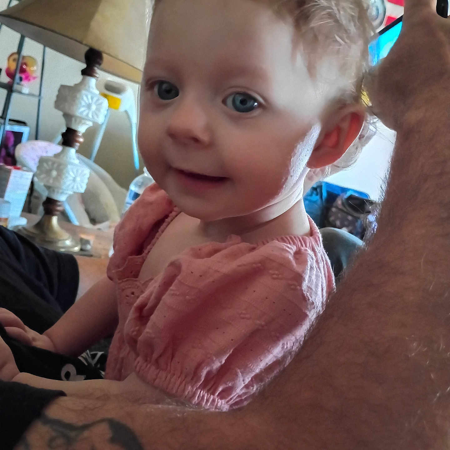 Bailey Lee is registered to the contest to win money with this photo: arm, blue_eyes, casual, child, cozy, curly_hair, cute, face, family, furniture, home, indoor, lamp, person, pink_dress, portrait, smile, tattoo, toddler, young_child