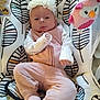 baby, baby_girl, baby_seat, child, comfort, cozy, cute, face, headband, indoors, infant, owl_toy, patterned_fabric, pink_clothing, plush_toy, portrait, relaxed, sitting, soft_toys, white_flower