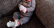 Bailey Lee joined the competition — help win amazing prizes! baby, child, comfortable, couch, cozy, cute, footwear, furniture, gray, home, indoor, infant, mittens, pajamas, person, polka_dot, sitting, smiling, soft_lighting, white