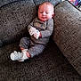 baby, child, comfortable, couch, cozy, cute, footwear, furniture, gray, home, indoor, infant, mittens, pajamas, person, polka_dot, sitting, smiling, soft_lighting, white