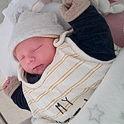 Nolan participe au concours pour gagner de l'argent avec cette photo : baby, newborn, sleeping, hat, blanket, clothing, infant, cute, face, peaceful, rest, soft, warm, bed, portrait, child, sleep, babywear, cozy, comfort