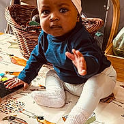 Isabelle joined the competition — help win amazing prizes! baby, child, headband, socks, blue_shirt, blanket, bird_pattern, basket, indoor, curious, sitting, hand, face, cozy, home, decor, wooden_chair, table, toy, infant