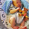 Griffin joined the competition — help win amazing prizes! baby, infant, sleeping, plush_toy, tiger_toy, baby_seat, blanket, soft_fabric, cute, child, peaceful, indoor, cozy, comfort, newborn, resting, clothing, hand, foot, face