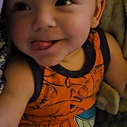 Damien joined the competition — help win amazing prizes! arm, baby, child, closeup, cozy, cute, expression, face, indoors, infant, legs, orange_outfit, patterned_clothing, person, playful, skin, smiling, soft, tongue_out, young