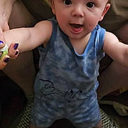 Damien joined the competition — help win amazing prizes! baby, child, person, blue_clothing, standing, indoor, adult_hand, floor, shirt, logo, burger_king, support, smiling, happy, footwear, nail_polish, holding, human, cute, expression