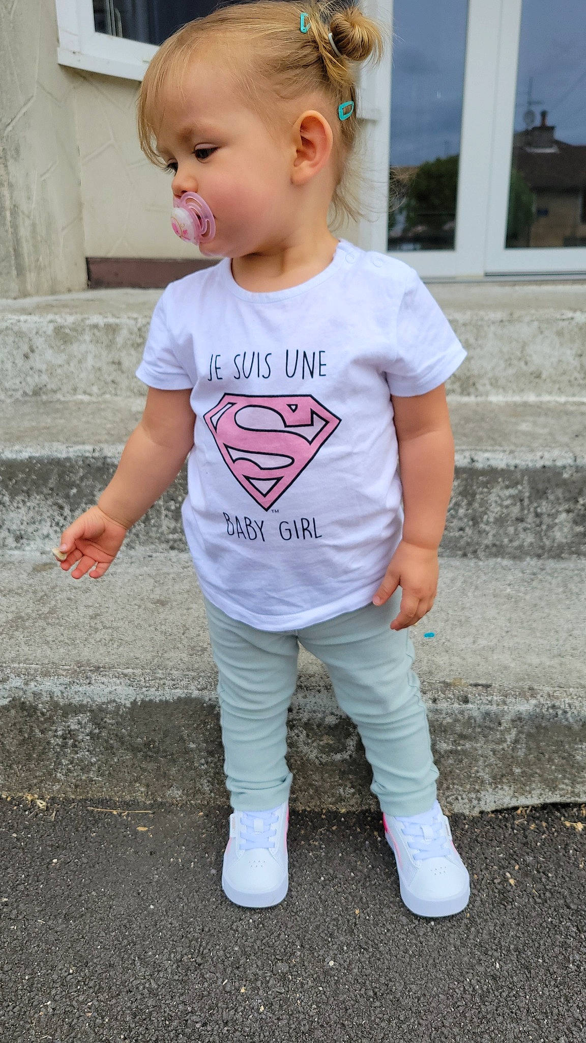 Mailys participe au concours pour gagner de l'argent avec cette photo : baby, baby_toddler_clothing, child, chin, clothing, electric_blue, face, grass, happy, head, joint, leg, person, pink, sleeve, smile, sportswear, standing, t_shirt, toddler
