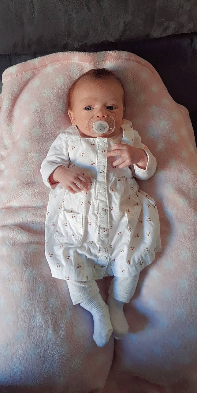 Mailys participe au concours pour gagner de l'argent avec cette photo : arm, baby, baby_products, baby_safety, baby_toddler_clothing, cheek, child, comfort, eye, face, finger, gesture, hand, linens, mouth, nail, person, skin, sleeve, thumb