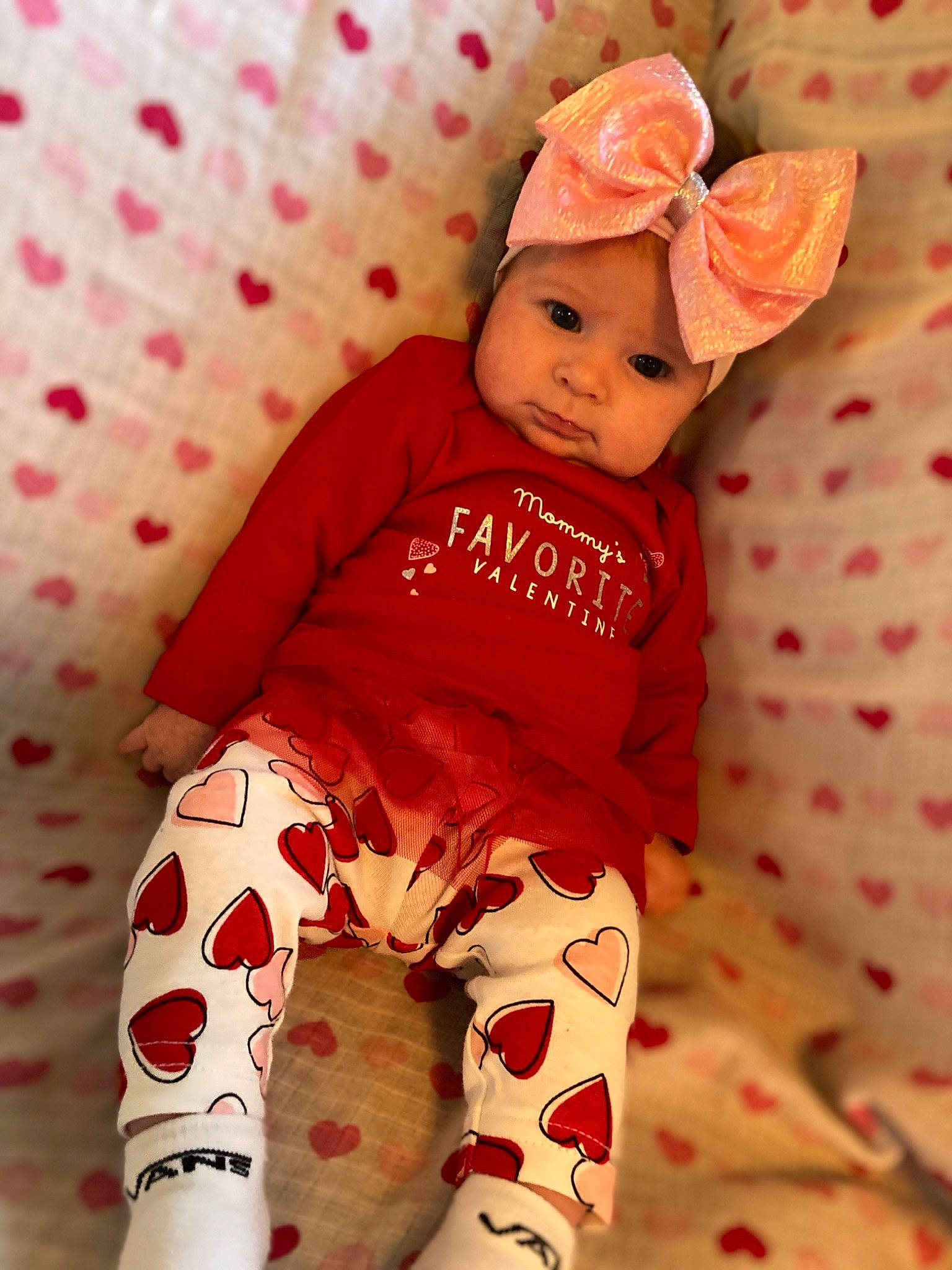 Harlee joined the competition — help win amazing prizes! arm, baby, baby_toddler_clothing, clothing, comfort, eye, face, hand, head, headwear, human_body, outerwear, pattern, person, pink, red, skin, sleeve, sock, textile