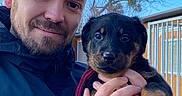 Freyja participe au concours pour gagner de l'argent avec cette photo : man, puppy, dog, outdoor, smile, jacket, hand, face, glasses, tree, sky, fence, building, portrait, animal, pet, watch, ring, holding, happy
