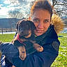 woman, puppy, dog, outdoor, sunlight, winter, jacket, smile, nature, grass, tree, sky, cloud, portrait, pet, countryside, fence, happy, warm_clothing, animal