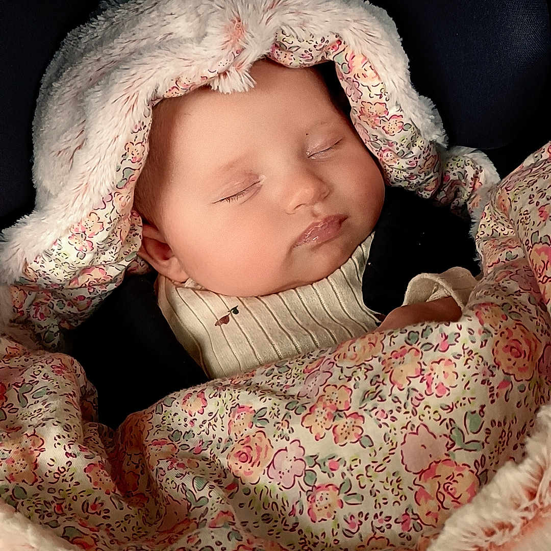 Lya participe au concours pour gagner de l'argent avec cette photo : baby, blanket, bodypart, bonnet, cap, clothing, face, finger, hand, hat, head, hood, hoodie, knitwear, newborn, person, photography, portrait, sweater, sweatshirt