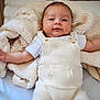 baby, infant, crib, blanket, knitted_clothing, white_shirt, smile, face, arm, wooden_bars, soft_texture, cozy, resting, cute, child, indoors, portrait, newborn, warm, comfort