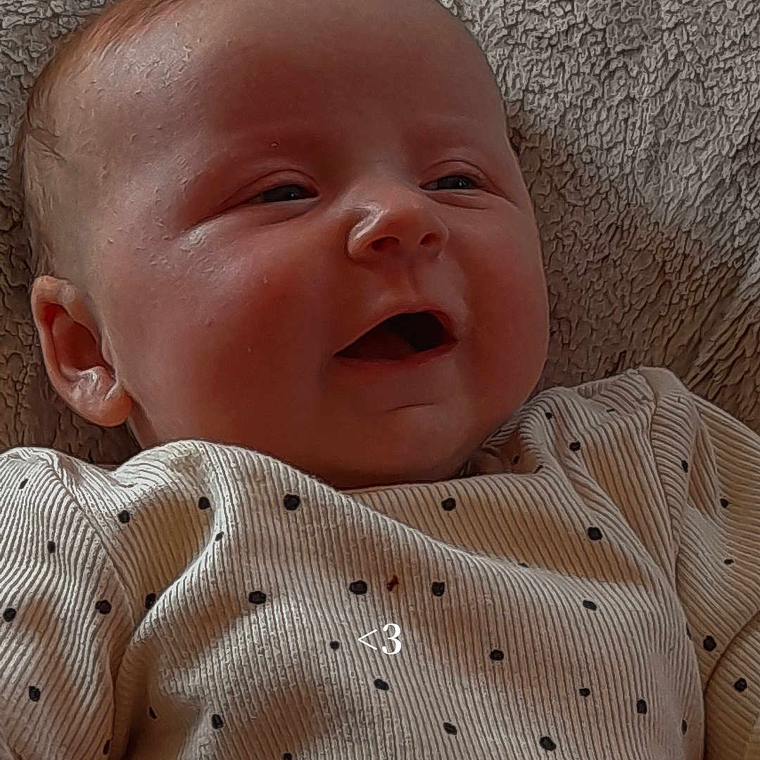 Lottie-Louise is registered to the contest to win money with this photo: baby, blanket, bodypart, clothing, coat, couch, face, finger, furniture, hand, happy, hat, head, knitwear, newborn, person, photography, portrait, smile, sweater