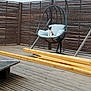 animal, backyard, calico_cat, calm, cat, cushion, daytime, empty_space, furniture, hanging_chair, home, outdoor, pet, quiet, relaxation, resting, string_lights, wooden_deck, wooden_fence, wooden_planks