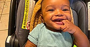 Purpose is registered to the contest to win money with this photo: baby, infant, child, smiling, portrait, car_seat, blanket, indoor, toy, activity_toy, teething_ring, sitting, happy, face, hand, clothing, short_sleeves, warm_lighting, floor_tiles, furniture