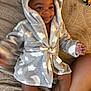 baby, child, smile, robe, hood, blanket, bed, toy, infant, cute, happy, skin, foot, hand, fabric, pattern, comfort, indoors, person, cozy