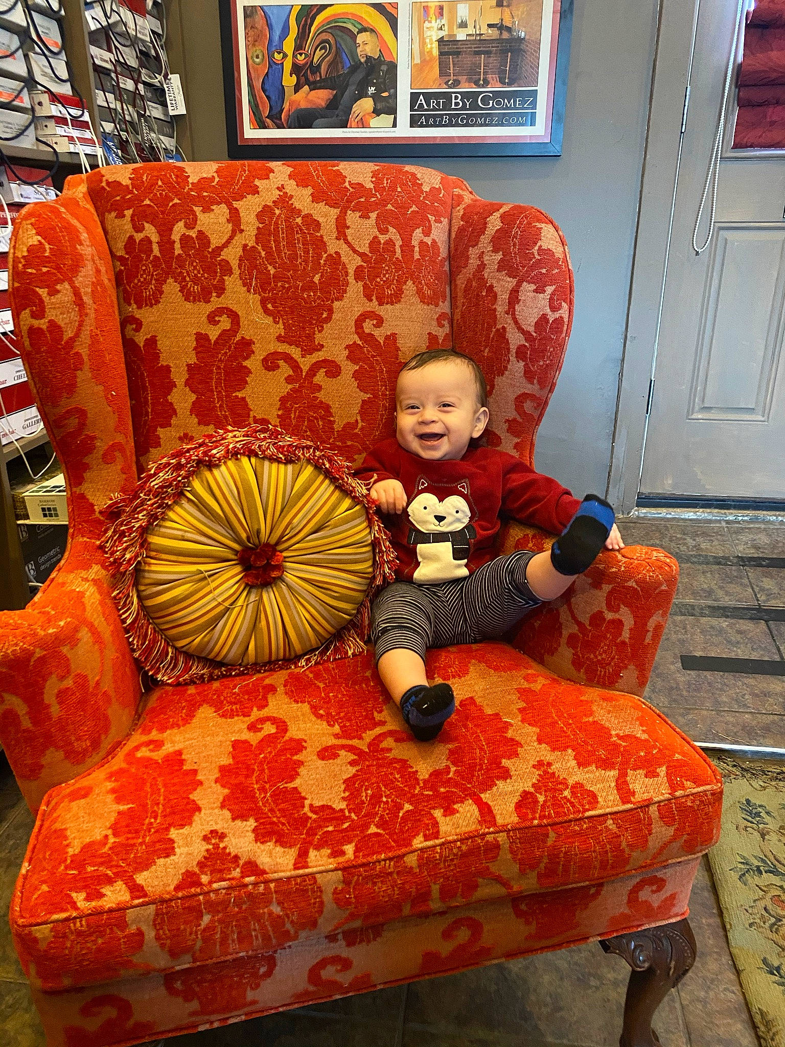 Daniel is registered to the contest to win money with this photo: baby_toddler_clothing, chair, child, classic, club_chair, comfort, couch, door, flooring, living_room, orange, person, picture_frame, pillow, room, sitting, smile, studio_couch, textile, toddler